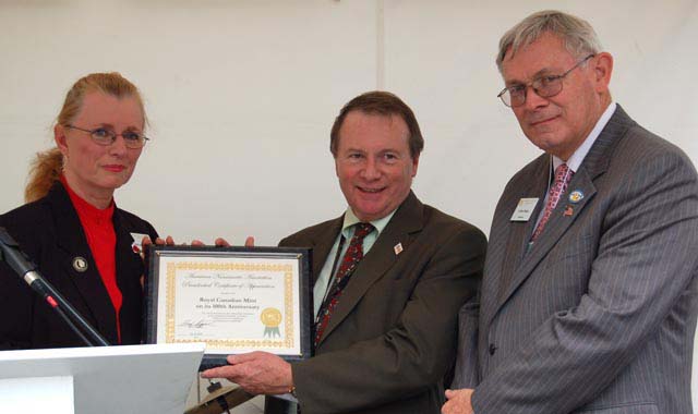 Patricia Jagger Finner, ANA Vice-President, presenting Ian Bennett with a Presidential Certificate of Appreciation to the Royal Canadian Mint on its 100th Anniversary. Clifford Mishler ANA Governor