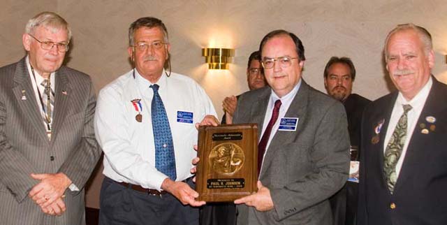(left to right) Cliff Mishler, ANA President, and Michael Turrini presenting the Krause Publications "Numismatic Ambassador" Award to Paul Johnson, while Michael Stanley observes at far right