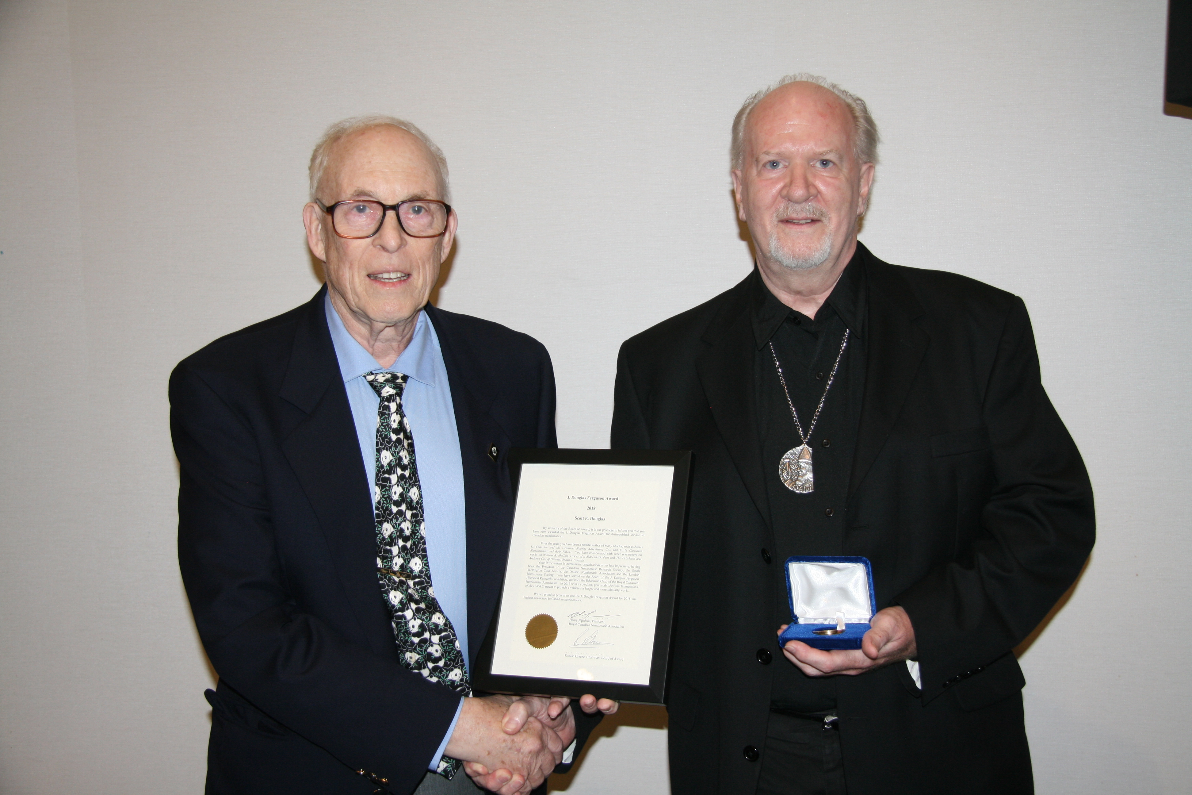 <p><strong>Scott E. Douglas</strong> receiving the Douglas J. Ferguson Award from <strong>Ron Greene</strong> (left).<br> <small>Dan Gosling photo</small></p>